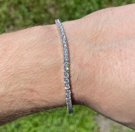 ARVANI 305 VVS1 Moissanite Tennis Bracelet in white gold worn on wrist outdoors on grass
